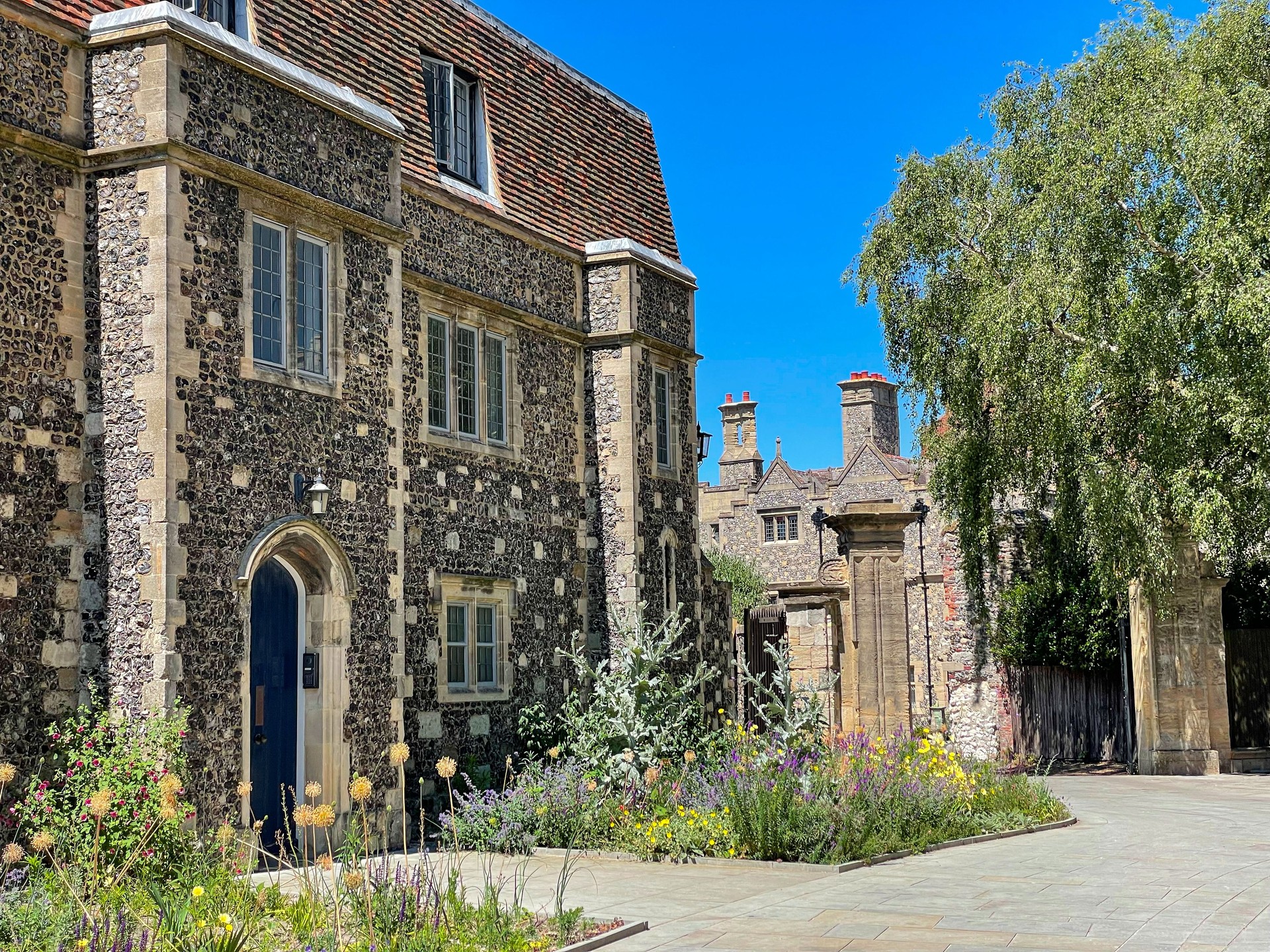 Flowering summer garden surrounds picturesque old stone townhouse in Canterbury